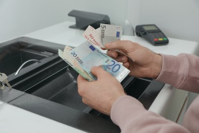 Man with money at cash department window, closeup. Currency exchange Photo of Man with money at cash department window, closeup. Currency exchange