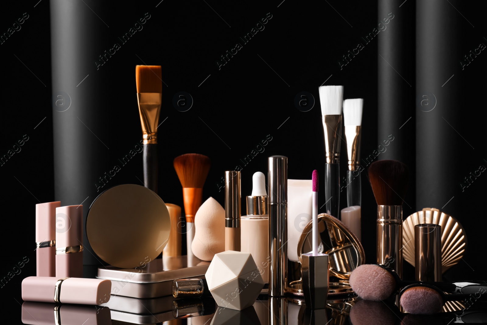 Composition with makeup products on table against black background Photo of Composition with makeup products on table against black background