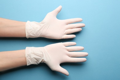 Person in medical gloves on blue background, closeup of hands Photo of Person in medical gloves on blue background, closeup of hands