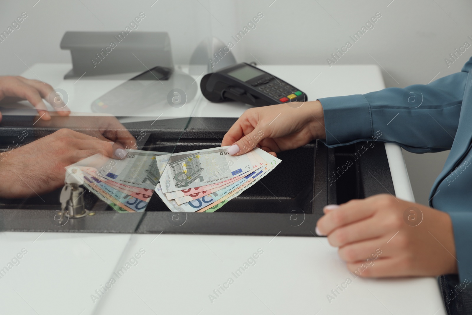 Woman giving money to cashier in bank, closeup. Currency exchange Photo of Woman giving money to cashier in bank, closeup. Currency exchange