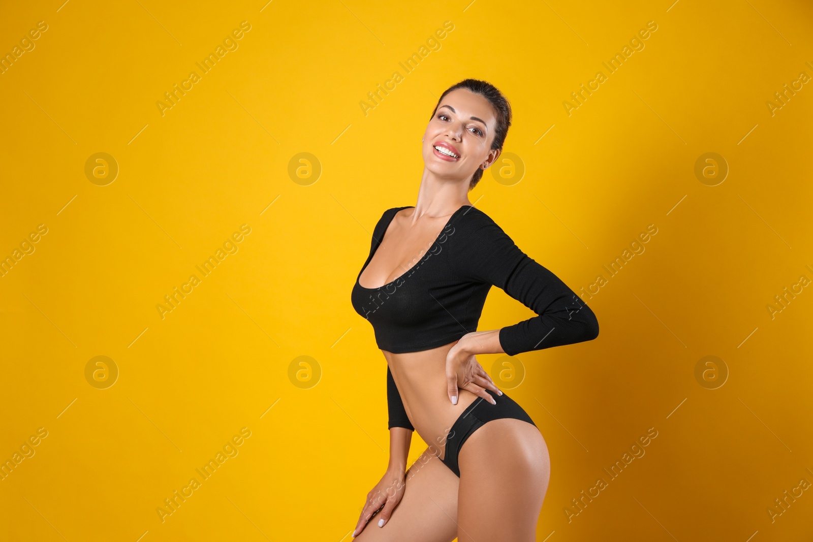 Beautiful woman in black sexy panties on yellow background, space for text Photo of Beautiful woman in black sexy panties on yellow background, space for text